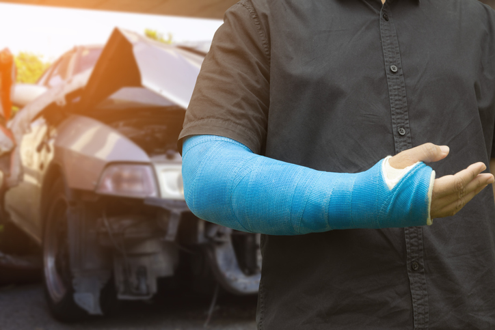 asian men wear cloth splint on arm to treat car accident injuries 