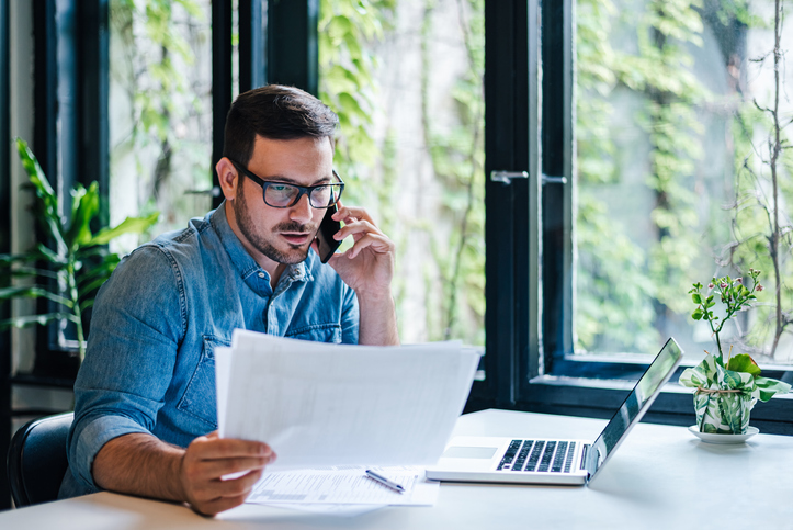 Man on the phone while analyzing documents - Can I fire my personal injury attorney?